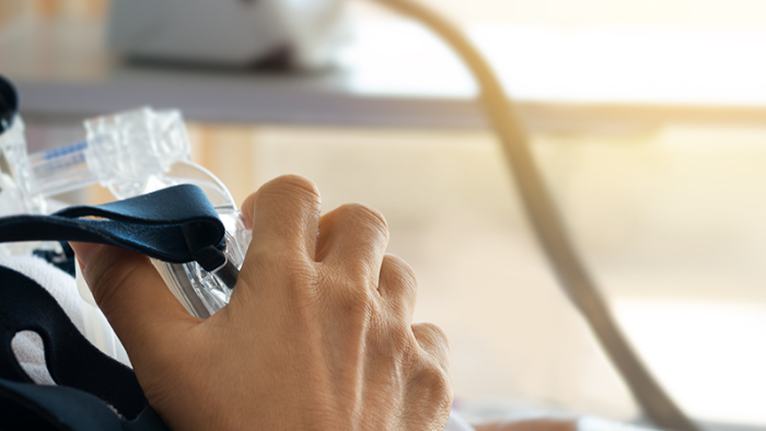 Patient in der Übergangspflege, der mit modernen medizinischen Geräten überwacht und von medizinischem Fachpersonal betreut wird